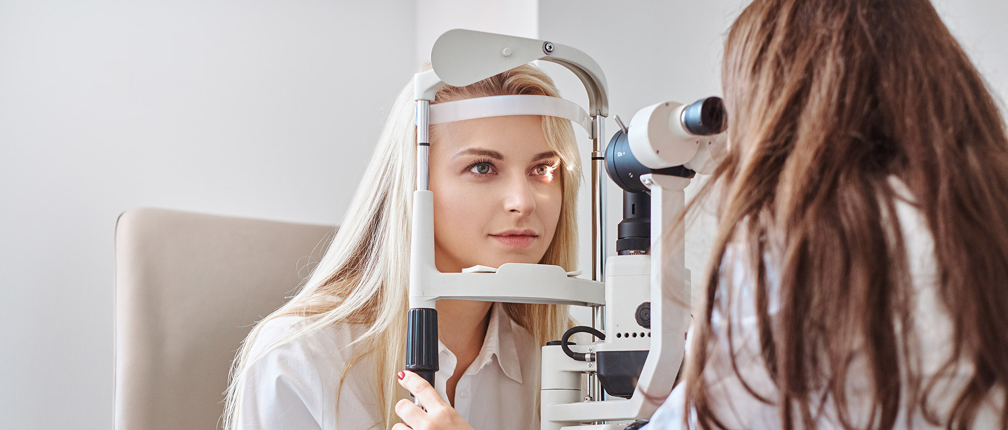 Attractive woman is doing eye test in optical clinic with experienced oculist.