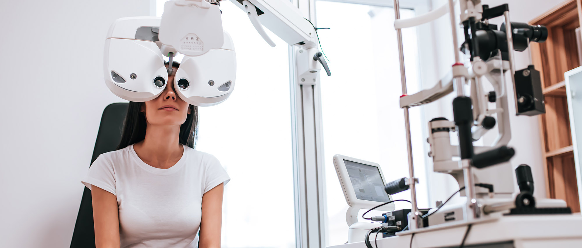 Attractive young woman is checking the eye vision in modern clinic. Patient in ophthalmology clinic